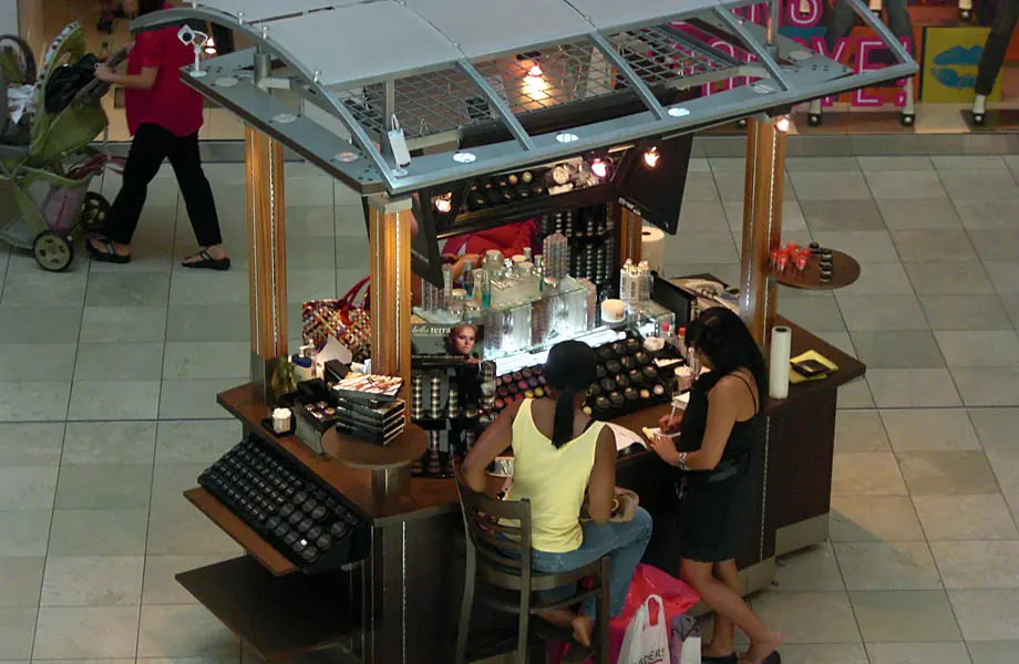 Shoppers getting their makeup done at a BELLATERRA kiosk