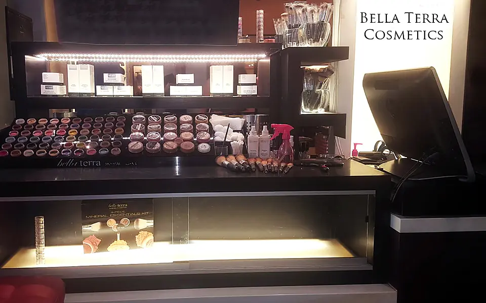 Lit BELLATERRA Cosmetics kiosk counter with rows of mineral makeup